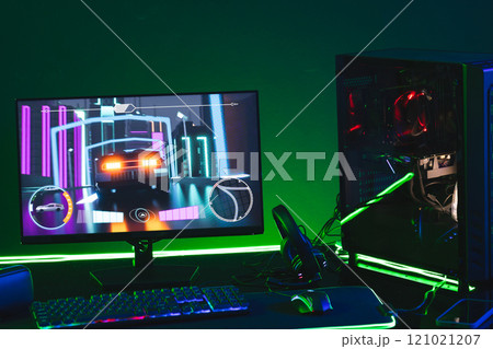 Composite of computer, keyboard with video game accessories with copy space on neon background 121021207