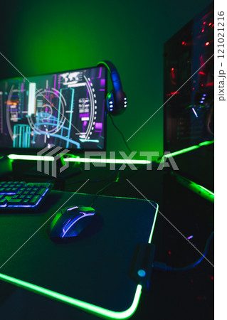 Vertical image of computer, keyboard with video game accessories with copy space on neon background 121021216