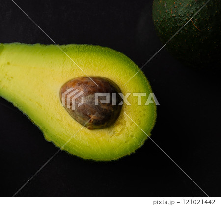 Micro close up of avocado with water drops and copy space on black background 121021442