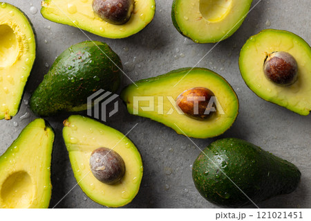Micro close up of avocados with water drops and copy space on grey background Micro close up of avocados with water drops and copy space on grey background 121021451
