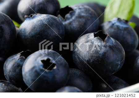 Micro close up of blueberries with copy space on green background Micro close up of blueberries with copy space on green background 121021452