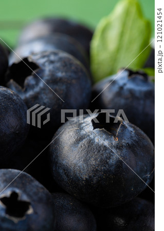 Micro close up of blueberries with copy space on green background Micro close up of blueberries with copy space on green background 121021454
