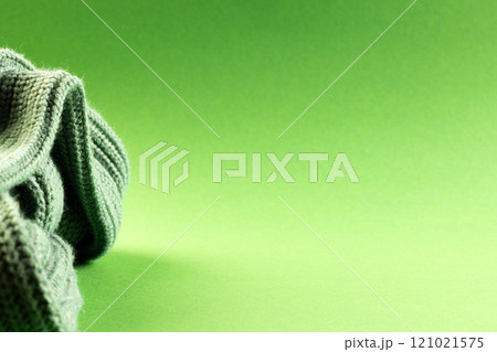 Micro close up of green wooly crochet fabric with copy space on green background 121021575