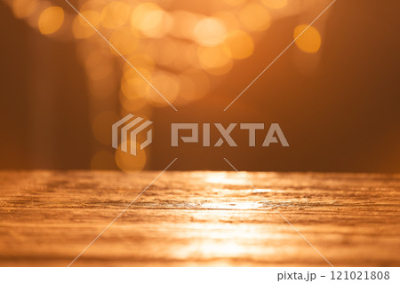 Yellow bokeh blurred lights with copy space and wooden surface on dark background 121021808