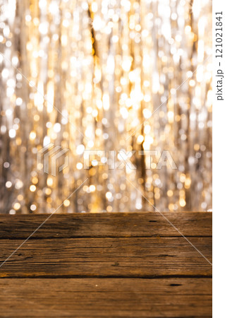 Vertical image of shining curtain and yellow bokeh lights with copy space and wooden surface 121021841
