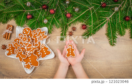 Gingerbread cookies and fir tree branch. Christmas holiday card. Christmas and New Year holidays, family celebration traditions. top view. copy space Gingerbread cookies and fir tree branch. Christmas holiday card. Christmas and New Year holidays, family celebration traditions. top view. copy space 121023046