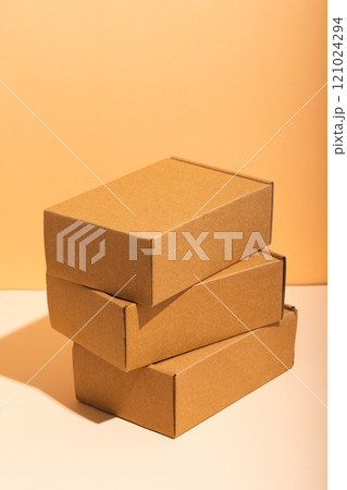 Vertical image of stack of cardboard gift boxes with copy space over yellow background Vertical image of stack of cardboard gift boxes with copy space over yellow background 121024294
