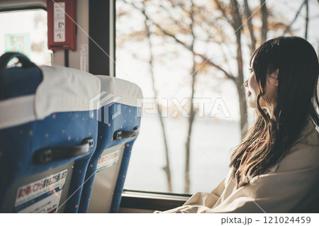 バスに乗って窓の外を眺める若い女性 121024459