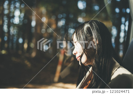 バスに乗って窓の外を眺める若い女性 121024471
