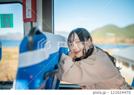 バスに乗って窓の外を眺める若い女性 121024478