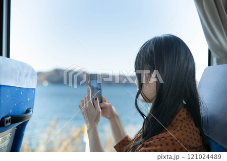 バスに乗って窓の外を眺める若い女性 バスに乗って窓の外を眺める若い女性 121024489