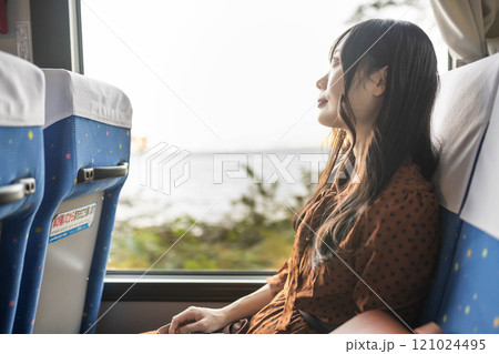 バスに乗って窓の外を眺める若い女性 121024495