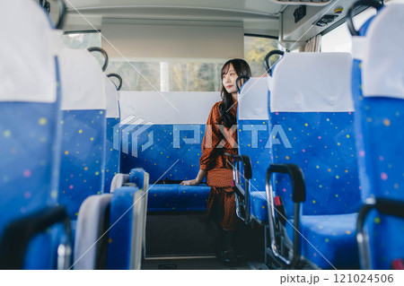 バスに乗って窓の外を眺める若い女性 121024506
