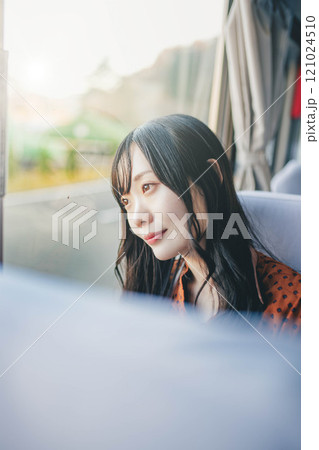 バスに乗って窓の外を眺める若い女性 バスに乗って窓の外を眺める若い女性 121024510