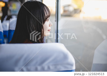 バスに乗って窓の外を眺める若い女性 バスに乗って窓の外を眺める若い女性 121024513