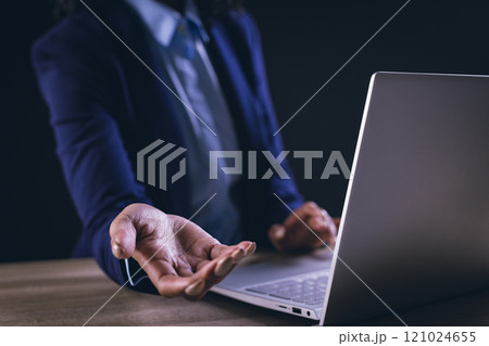 Biracial businesswoman using laptop and holographic display with copy space on black background 121024655