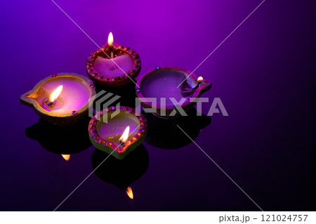 Close up of four diwali candles with copy space on purple background Close up of four diwali candles with copy space on purple background 121024757