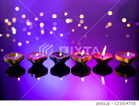 Close up of six diwali candles with copy space on purple background Close up of six diwali candles with copy space on purple background 121024758