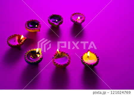 Close up of seven diwali candles with copy space on purple background 121024769