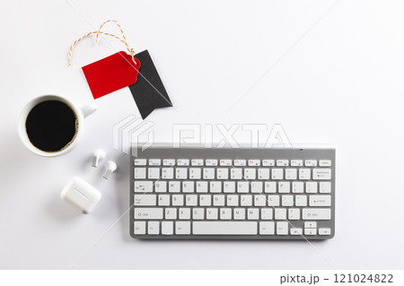 Computer keyboard, cup of coffee, wireless earphones, gift tags with copy space on white background Computer keyboard, cup of coffee, wireless earphones, gift tags with copy space on white background 121024822