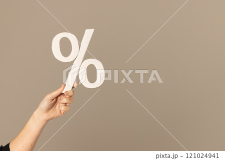 Video of hand of caucasian woman holding white percent sign with copy space against grey background 121024941