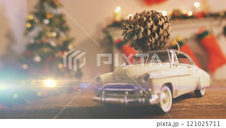 Composition of light over christmas decorations with car and pine cone 121025711