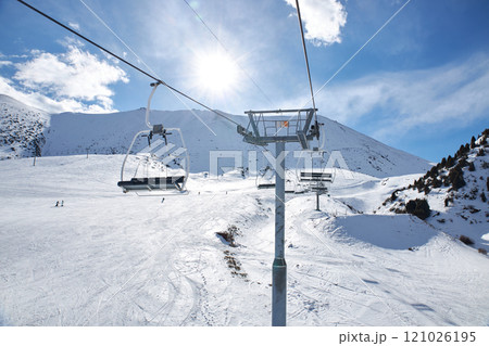 Chunkurchak ski resort. Empty ski lift seats. Mountain slope at sunny winter day 121026195