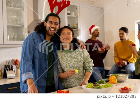 Multiracial friends celebrating christmas in kitchen, preparing salad at home 121027885