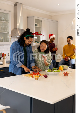 Christmas time, multiracial friends preparing holiday meal together in kitchen, at home 121027889