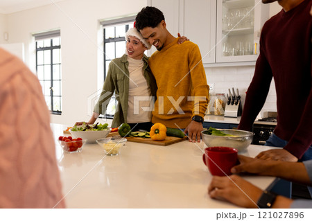 Christmas time, young multiracial friends preparing festive meal together in kitchen, at home 121027896