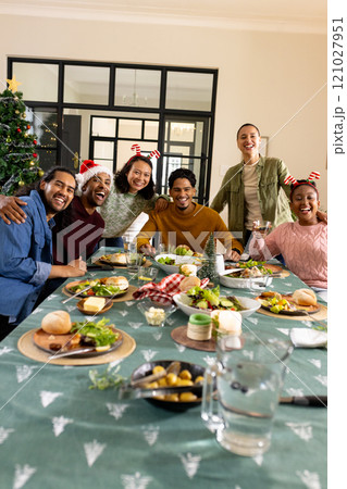 Young multiracial friends celebrating christmas together, at home Young multiracial friends celebrating christmas together, at home 121027951