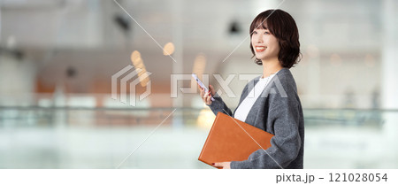 スマホとバインダーを持つ笑顔の女性・ビジネスウーマン 121028054