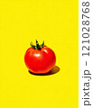 Vivid red tomato on bright yellow background showcasing fresh produce 121028768