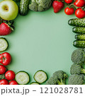 Fresh fruits and vegetables arranged on green background with copy space 121028781