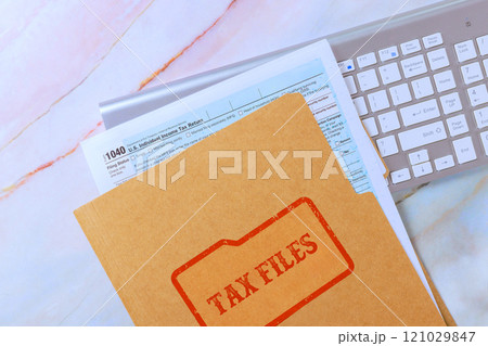 1040 tax form file computer keyboard on workspace suggest preparation for tax season financial planning. 121029847