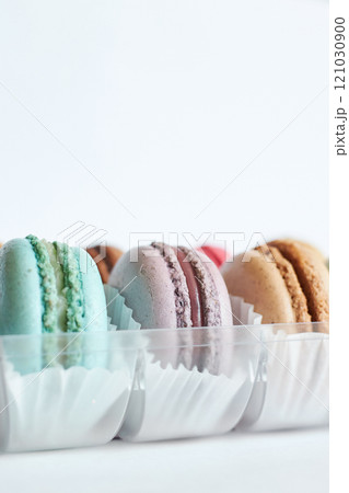 close up bright French Macarons with white paperpan in plastic box close up bright French Macarons with white paperpan in plastic box 121030900