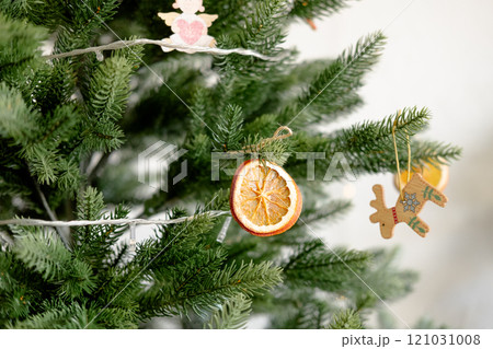 a piece of dried orange on a Christmas tree, close-up. DIY eco decorations for the Christmas tree 121031008