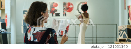 Visitor of modern gallery with brochure Visitor of modern gallery with brochure 121031540