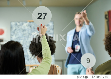 Young woman taking part in bidding Young woman taking part in bidding 121031750