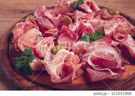 Assortment , sliced meat appetizer, prosciutto, salami and ham, with olives, on a wooden board, breakfast, top view, close-up, no people, Assortment , sliced meat appetizer, prosciutto, salami and ham, with olives, on a wooden board, breakfast, top view, close-up, no people, 121031906