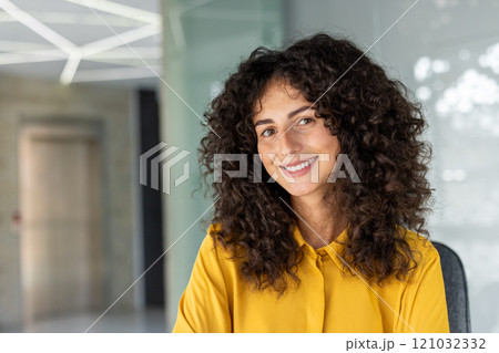 Happy woman in modern office setting. Bright smile conveys confidence, positivity in workplace. Ideal for business, professional, inspiration concepts. Happy woman in modern office setting. Bright smile conveys confidence, positivity in workplace. Ideal for business, professional, inspiration concepts. 121032332