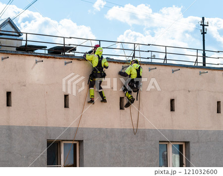 industrial climbers on wall of multi-storey house 121032600