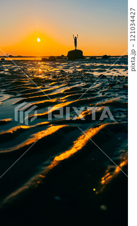 ribbed sand on the beach on the white sea and the figure of a teenage boy 121034427
