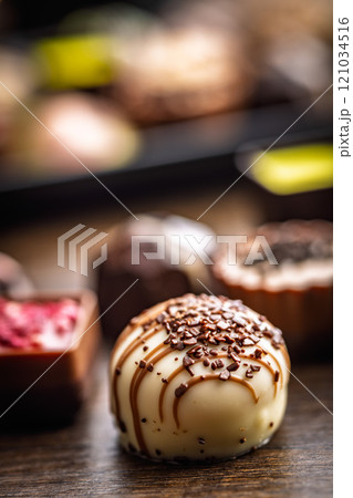 Mix of chocolate pralines on wooden table. 121034516