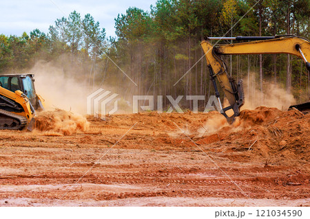 During excavation an earthmoving small mini tractor is leveling ground for construction 121034590