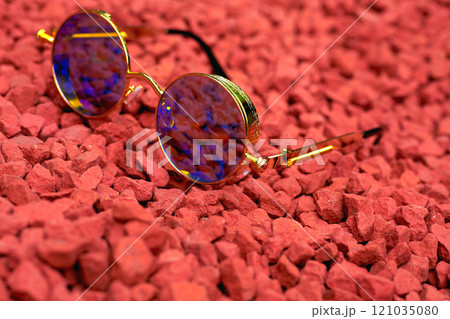Vintage cool gold sunglasses with blue lenses on pebbles red stones Vintage cool gold sunglasses with blue lenses on pebbles red stones 121035080