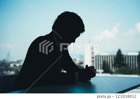 パワハラなどのストレスで悔しい・怒る・悲しい・辛い落ち込むビジネスマンのシルエット パワハラなどのストレスで悔しい・怒る・悲しい・辛い落ち込むビジネスマンのシルエット 121038012