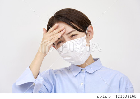 風邪マスクを付けて頭痛がする女性 白背景 風邪マスクを付けて頭痛がする女性 白背景 121038169
