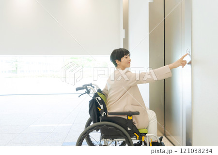 エレベーターに乗ろうとする車椅子の女性 121038234