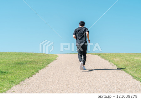 青空の下でランニング・ジョギングをする男性（アスリート・有酸素運動・ワークアウト・フィットネス） 121038279